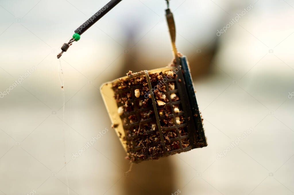 throwing a filled feeder . Closeup of feeder fishing.