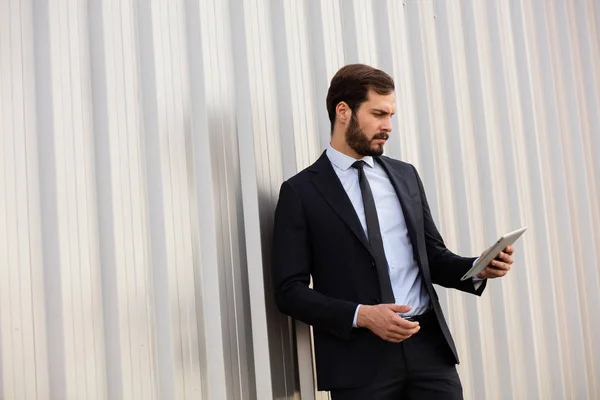 Κομψό επιχειρηματίας χρησιμοποιώντας ένα tablet εκτός — Φωτογραφία Αρχείου