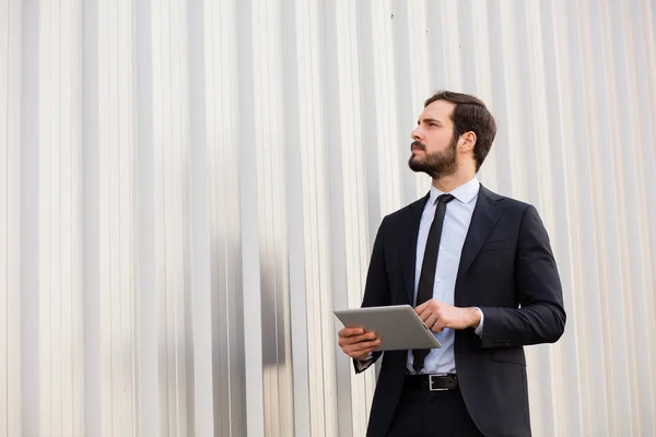 Hombre de negocios elegante usando una tableta fuera —  Fotos de Stock