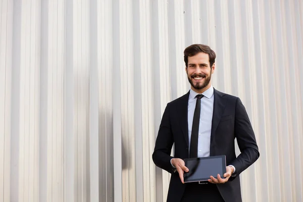 Hombre elegante guapo en traje presentando la pantalla de su tableta —  Fotos de Stock