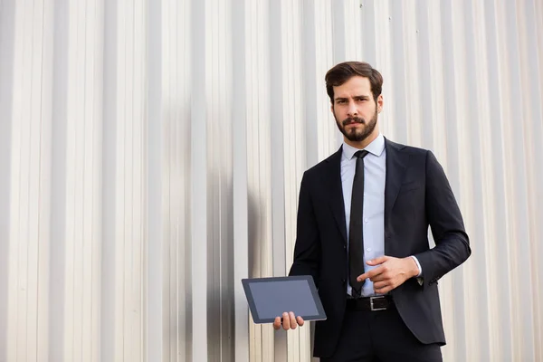Knappe elegante man in pak het scherm van zijn tablet presenteren — Stockfoto