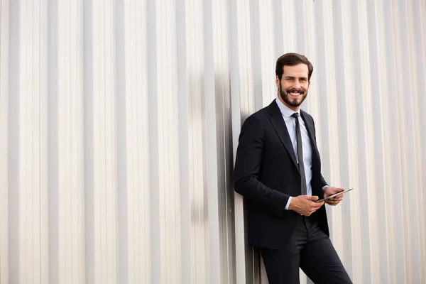 Happy elegant man med en tablett i händer — Stockfoto