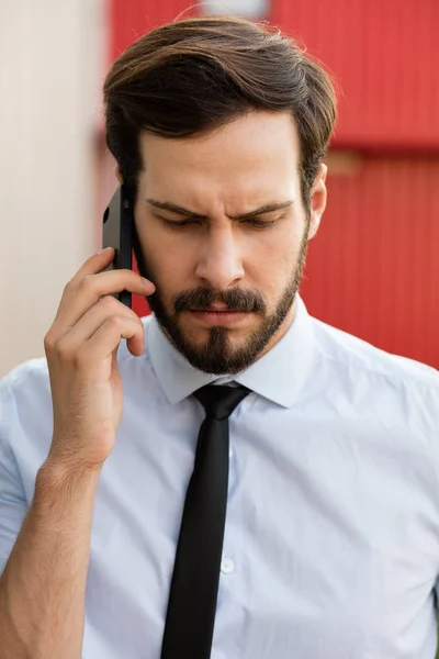 Clouse upp av en man i blå skjorta och slips som pratar i mobiltelefon — Stockfoto