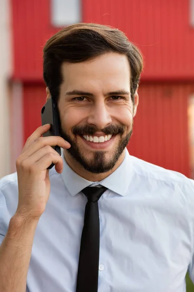 Clouse up of a man in blue shirt and tie talking at cellphone — Stock Photo, Image