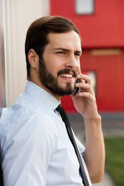 Clouse up of a man in blue shirt and tie talking at cellphone — Stock Photo, Image