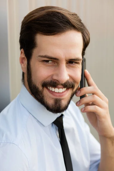 Clouse upp av en man i blå skjorta och slips som pratar i mobiltelefon — Stockfoto