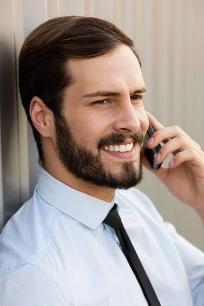 Apertar-se de um homem de camisa azul e gravata falando no celular — Fotografia de Stock