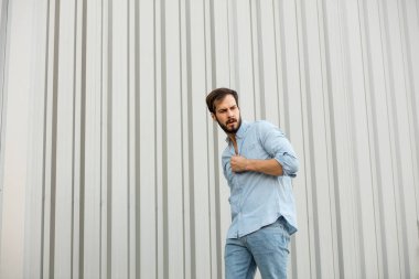 Gri arka plan üzerinde sakallı yakışıklı genç adam