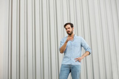 Gri arka plan üzerinde sakallı yakışıklı genç adam