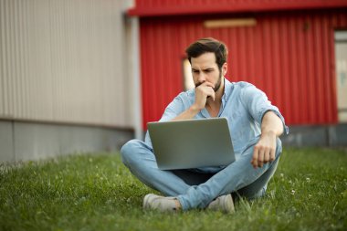 Genç adam onun laptop f ile yatarken rahat kot kıyafeti