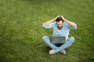 Genç adam onun laptop f ile yatarken rahat kot kıyafeti