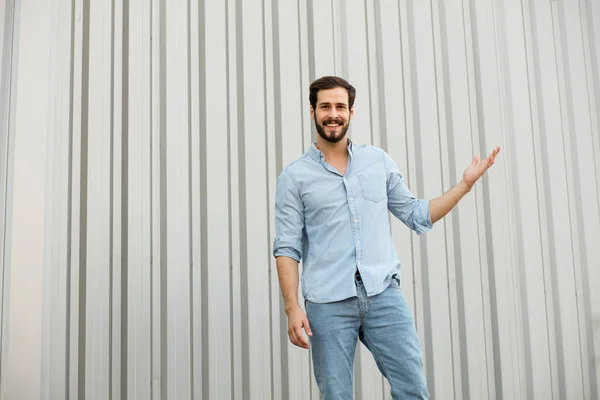 Bello giovane uomo con la barba su sfondo grigio — Foto Stock