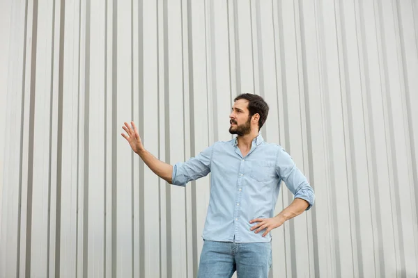 Bonito jovem com barba no fundo cinza — Fotografia de Stock