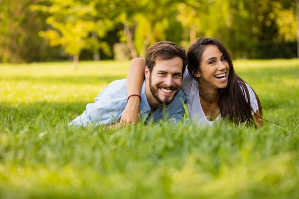 Hombre y mujer acostados en hierba verde cerca uno del otro — Foto de Stock