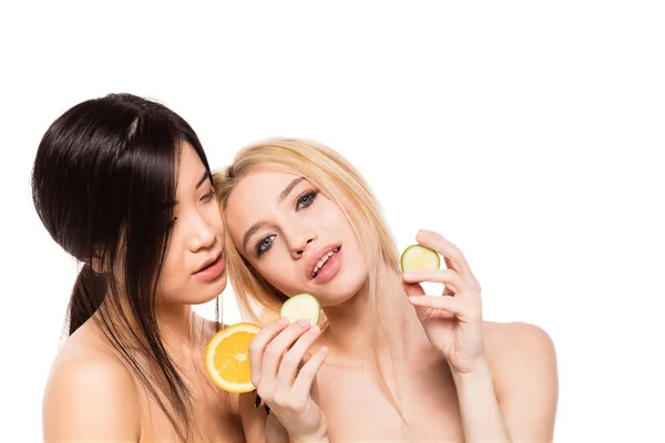 Dvě různé etnické ženy s pomerančem a okurka — Stock fotografie