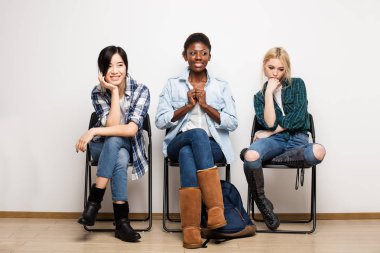 Röportaj için sırada bekleyen üç farklı etnik kadınlar