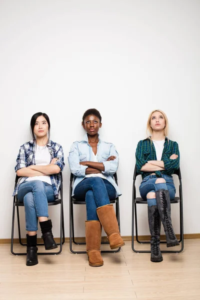 Drie verschillende etnische vrouwen wachten in de rij voor interview — Stockfoto