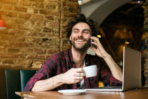 Giovane con computer portatile davanti in un pub — Foto Stock