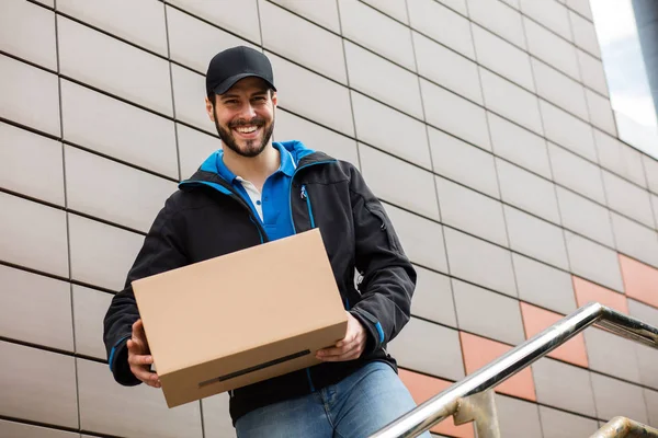 Delivery man with cardboard in hands — Stock Photo, Image