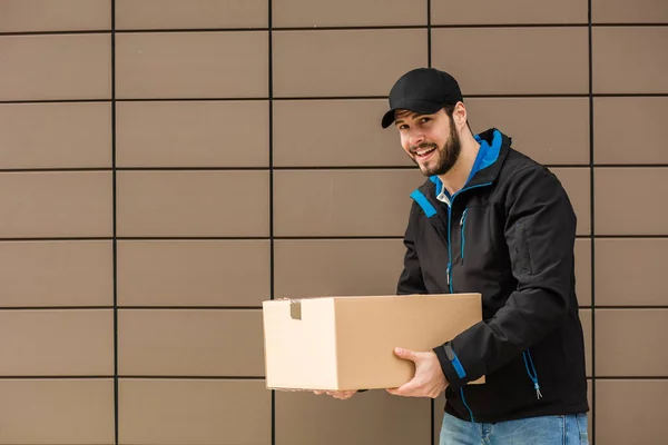 Leverans mannen med kartong i händer — Stockfoto