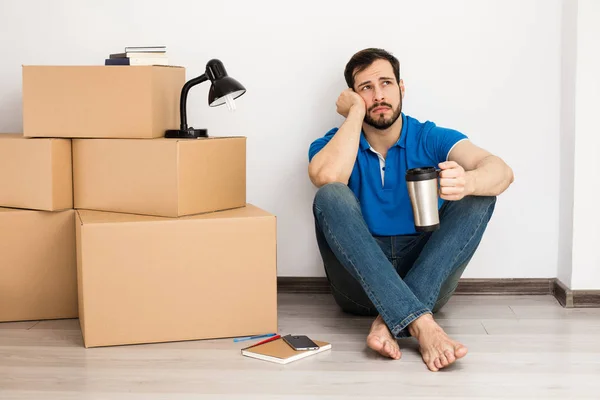 man lying on the floor with packing boxes