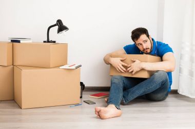 kutu ambalaj ile yerde yatan adam 