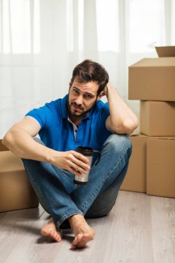 arkasında kutu ambalaj ile yerde yatan adam
