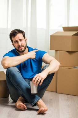 arkasında kutu ambalaj ile yerde yatan adam