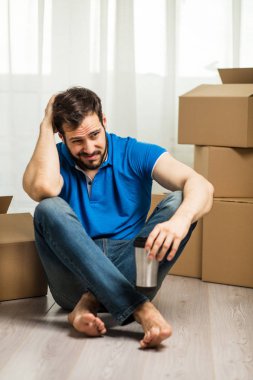 arkasında kutu ambalaj ile yerde yatan adam