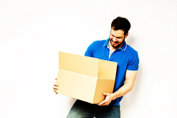 A fiatalember egy karton doboz, a karjában — Stock Fotó