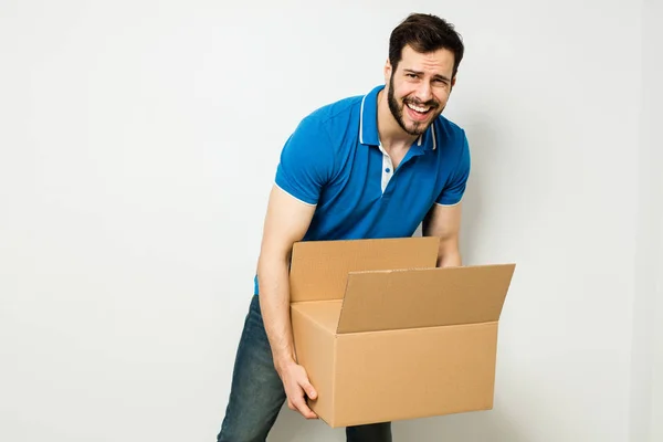 Young man with a cardboard box in his arms — Stock Photo, Image