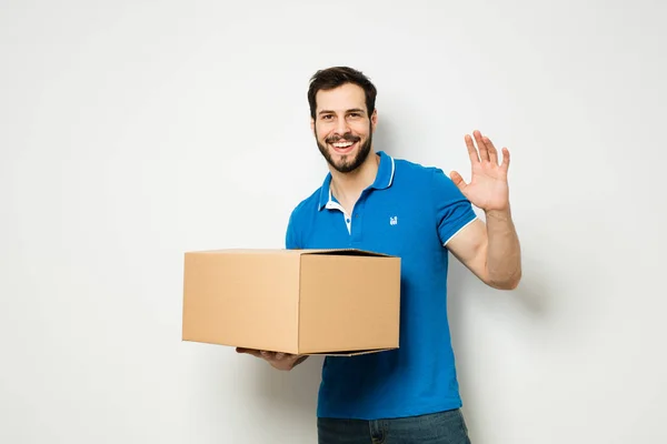 Jonge man met een kartonnen doos in zijn armen — Stockfoto