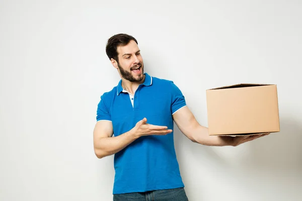 Young man with a cardboard box in his arms — Stock Photo, Image