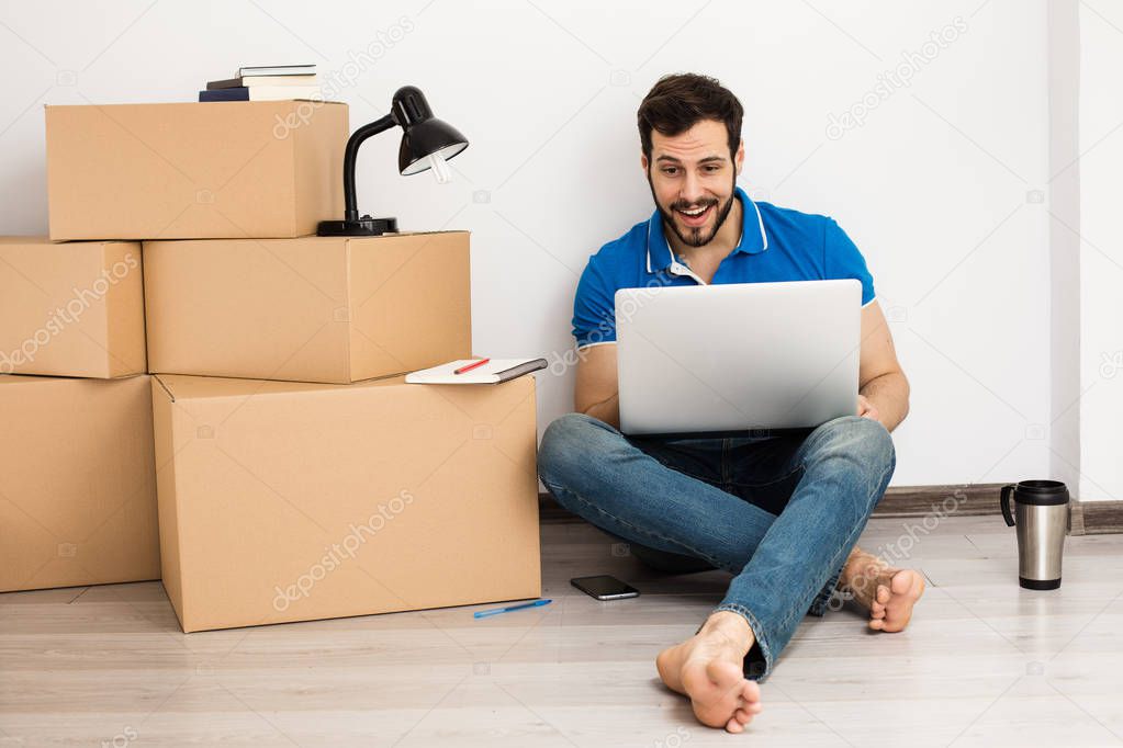 man lying on the floor with packing boxes 