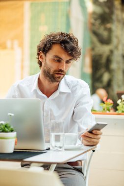 zarif yakışıklı dışında bir kafeterya masada çalışma