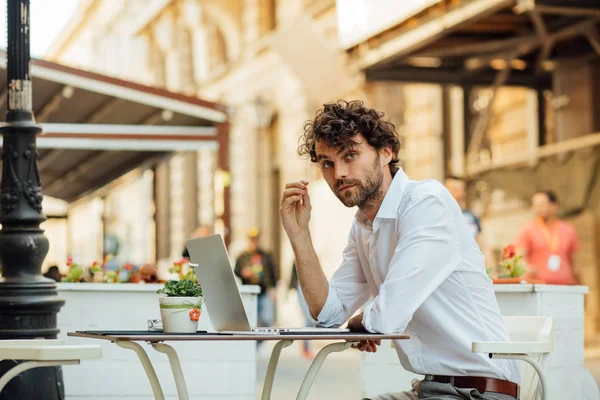 Guapo elegante hombre trabajando fuera en una mesa de café — Foto de Stock