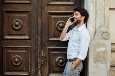 ahşap bir kapı önünde ayakta olgun adam