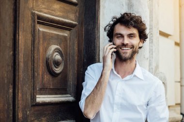 ahşap bir kapı önünde ayakta olgun adam