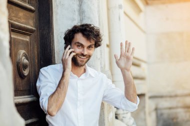 ahşap bir kapı önünde ayakta olgun adam