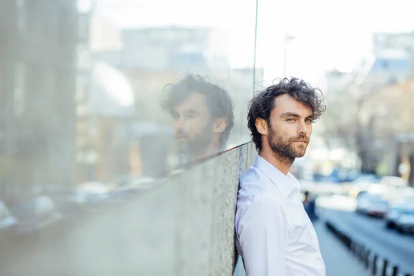 Guapo elegante hombre stanting fuera contra un gris pared — Foto de Stock