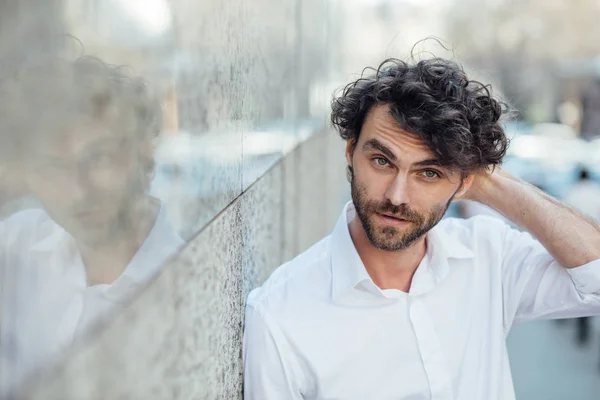 Guapo elegante hombre stanting fuera contra un gris pared — Foto de Stock