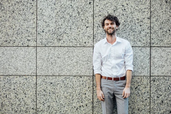 Bello uomo elegante stanting fuori contro un muro grigio — Foto Stock