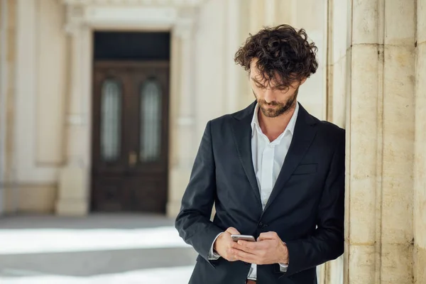 Snygg elegant man står utanför mot en kolumn i en ol — Stockfoto