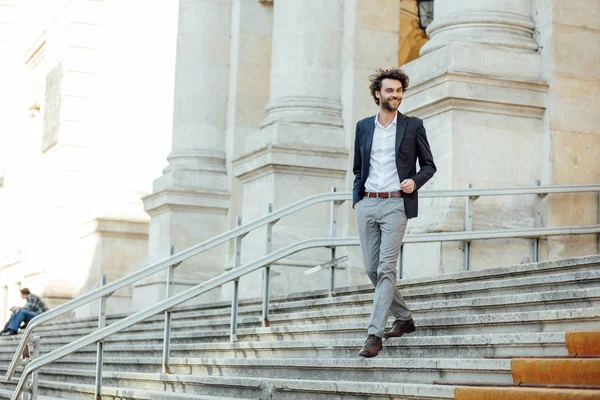 Schöner eleganter Mann, der die Treppe eines Gebäudes hinuntersteigt — Stockfoto