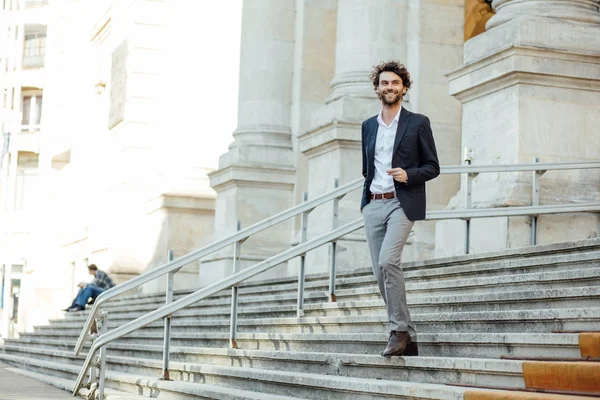 Schöner eleganter Mann, der die Treppe eines Gebäudes hinuntersteigt — Stockfoto