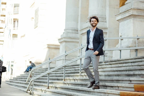 Schöner eleganter Mann, der die Treppe eines Gebäudes hinuntersteigt — Stockfoto