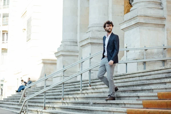 Schöner eleganter Mann, der die Treppe eines Gebäudes hinuntersteigt — Stockfoto