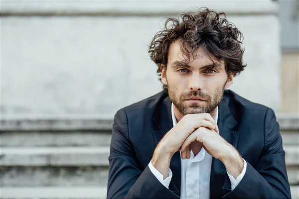 Adulto y elegante hombre sentado fuera en las escaleras — Foto de Stock