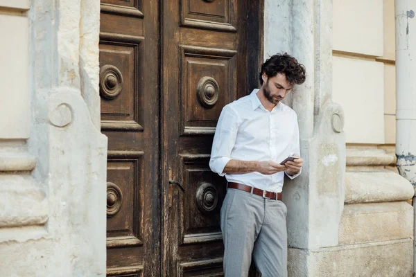 Uomo maturo in piedi davanti a una porta di legno — Foto Stock