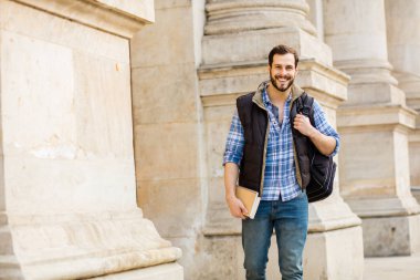 bir klasik BI ile binada arkasında sahip sırt çantası ile genç adam
